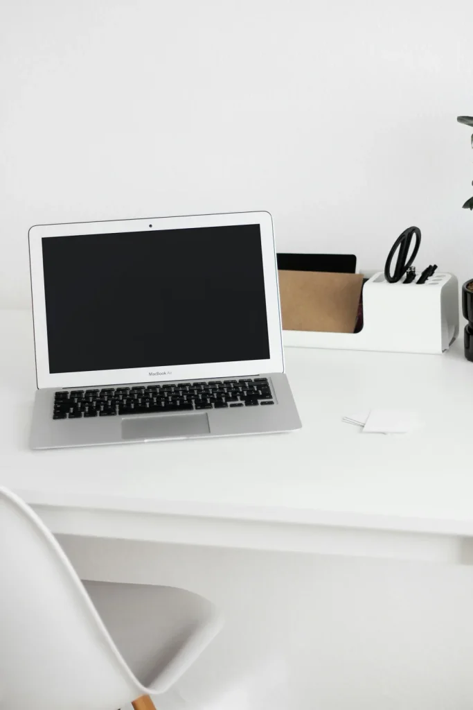 Illustration : ordinateur portable ouvert sur un bureau blanc.